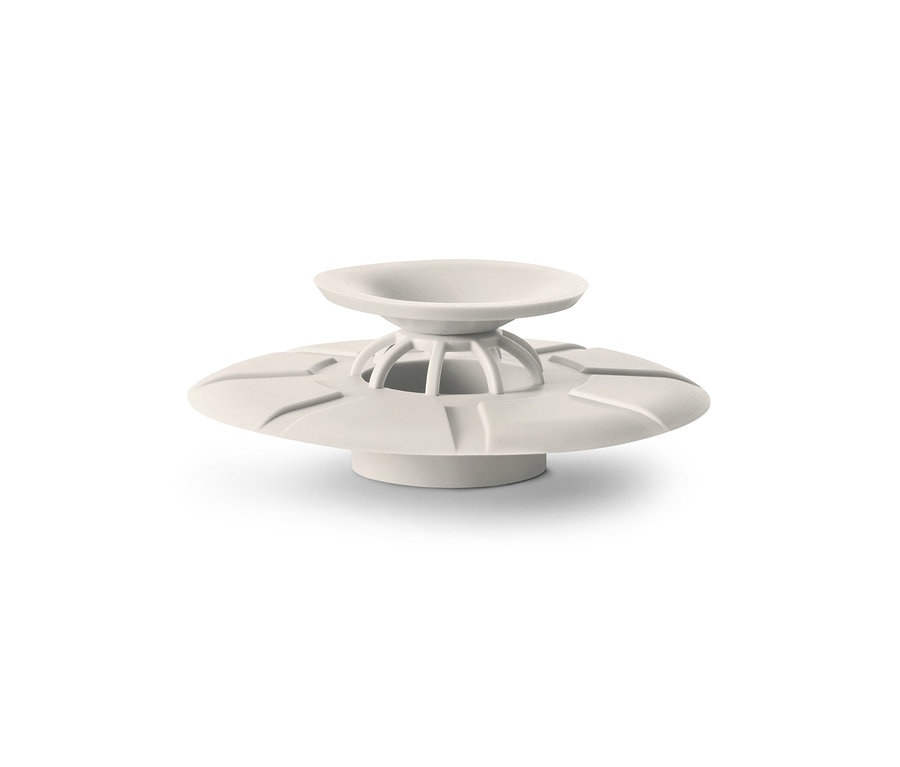 Bílé odtokové sítko a zátka na bílém pozadí.