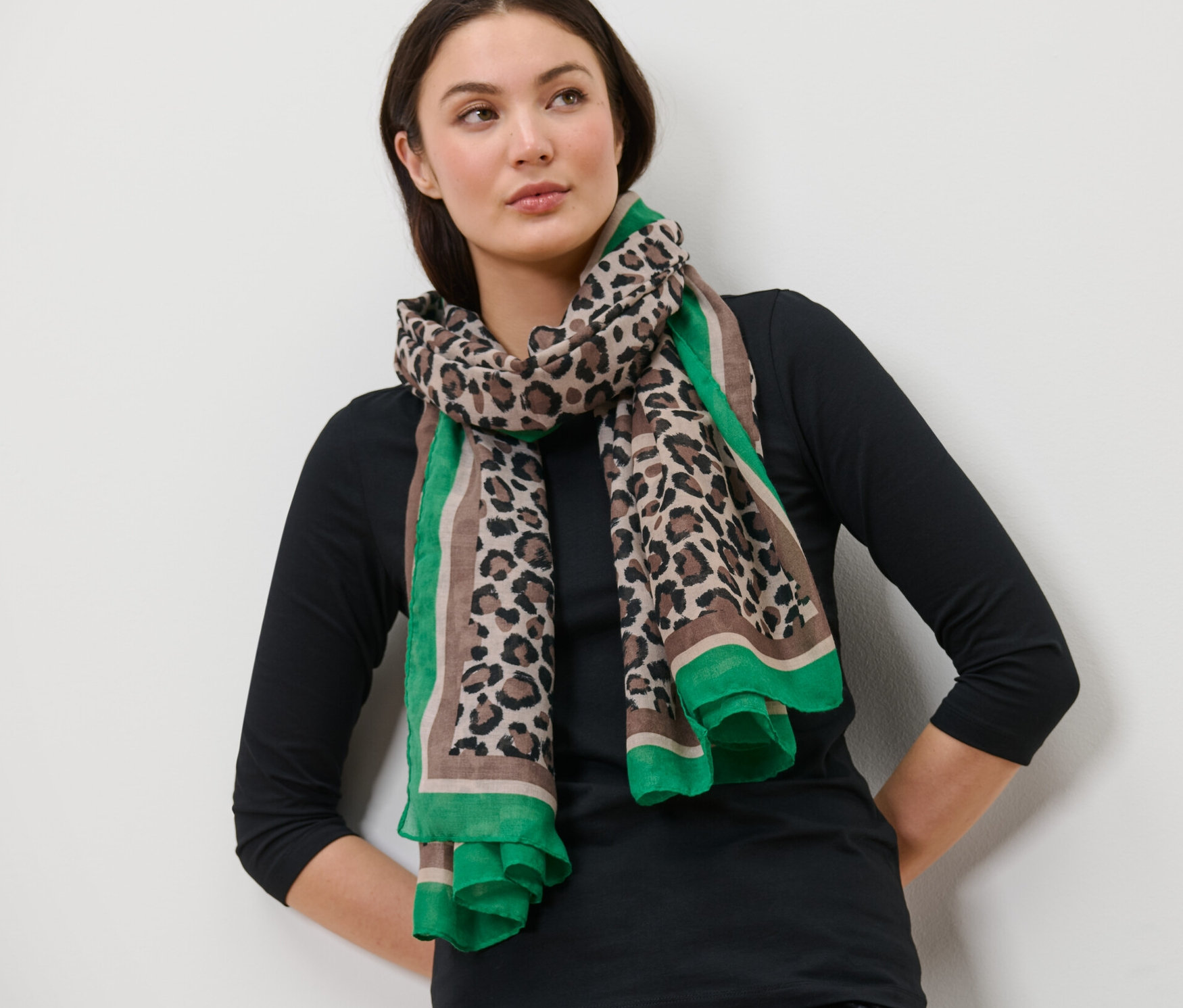 Žena má na sobě tkanou šálu s potiskem.