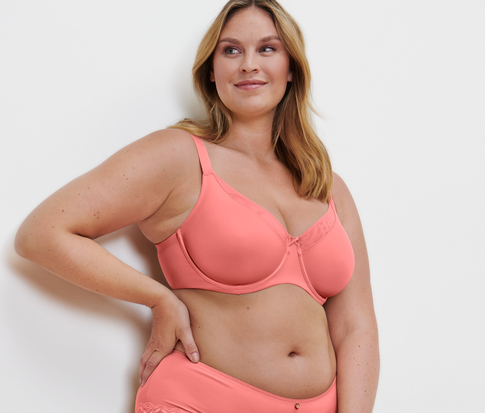 Blondýna pózuje v papájové zmenšující podprsence a kalhotkách s krajkou.