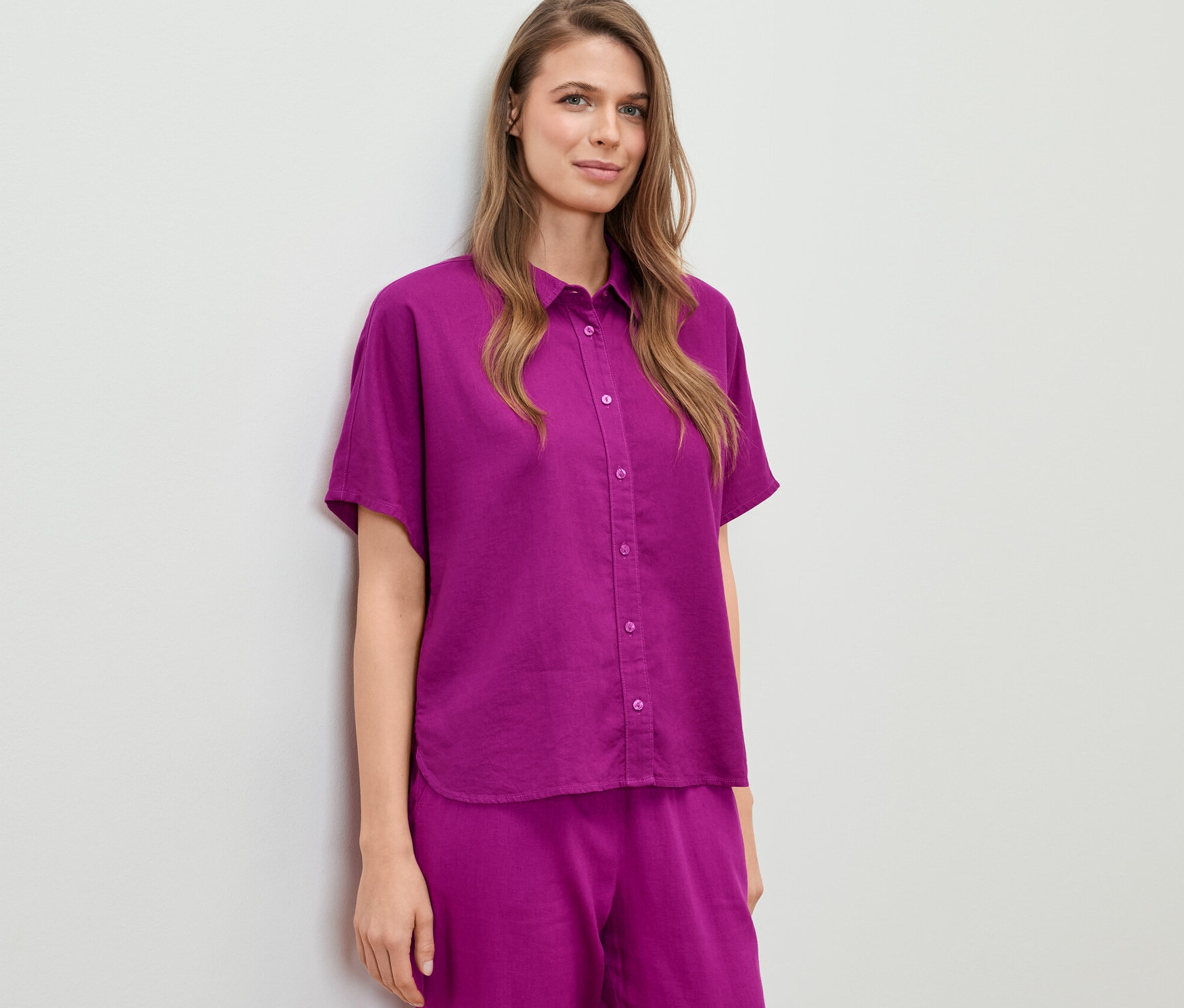 Žena má na sobě lněnou halenku.