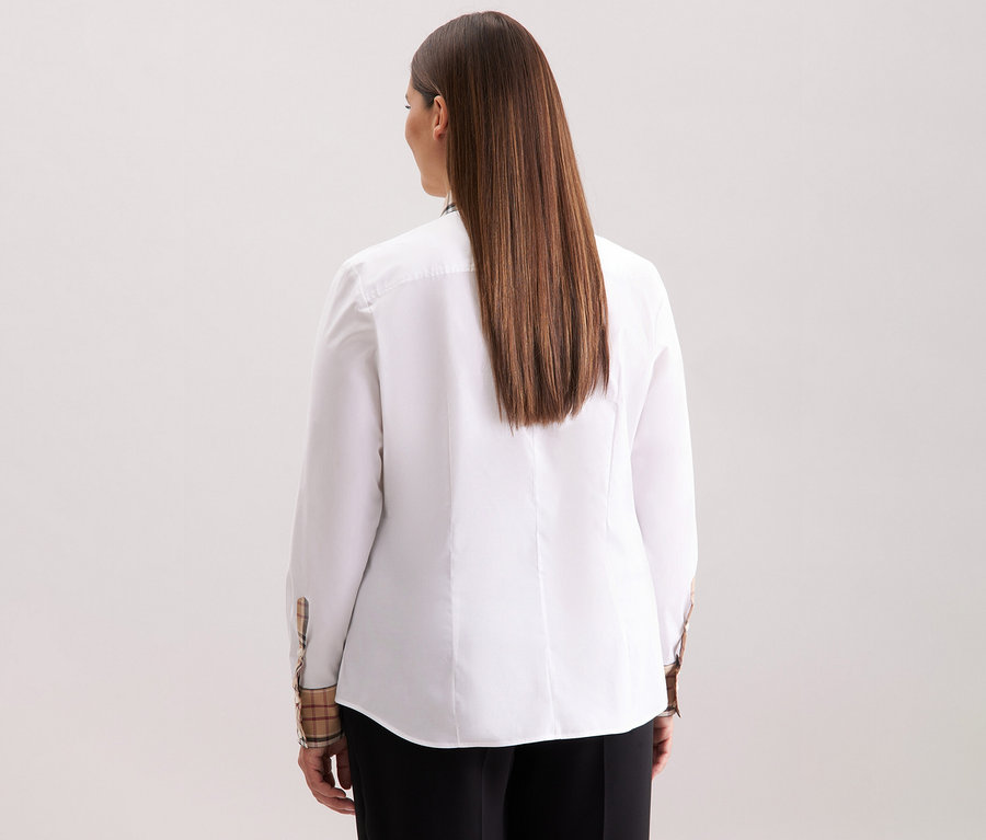 Pohled zezadu na ženu s dlouhými hnědými vlasy v bílé popelínové halence s kostkovaným detailem Seidensticker.