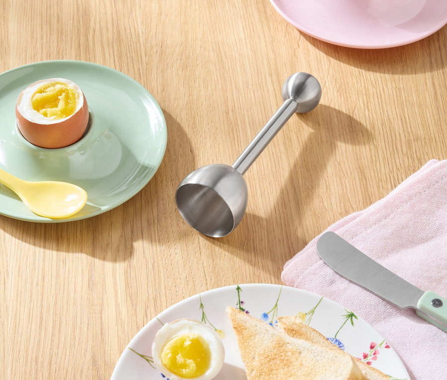 Toast, vejce a nůž na dřevěném stole.