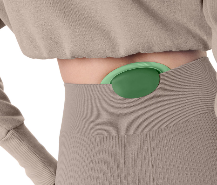 Žena má v kalhotách zasunutý zelený masážní míček.