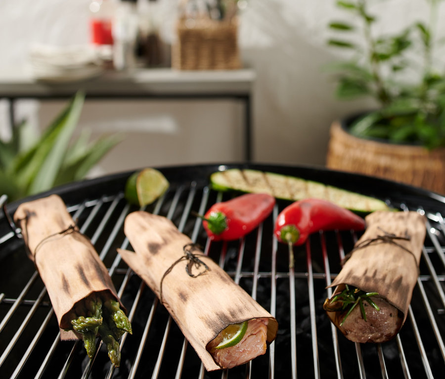 Gril s grilovacím papírem z bukového dřeva, paprikami, cuketou a limetkou.