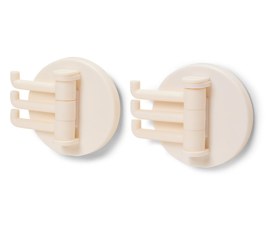 Dva krémové otočné háčky na bílém pozadí.