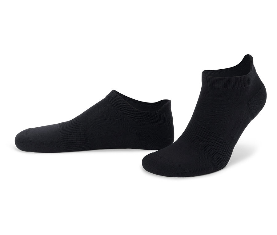 Dvě černé kotníkové ponožky leží na bílém pozadí.
