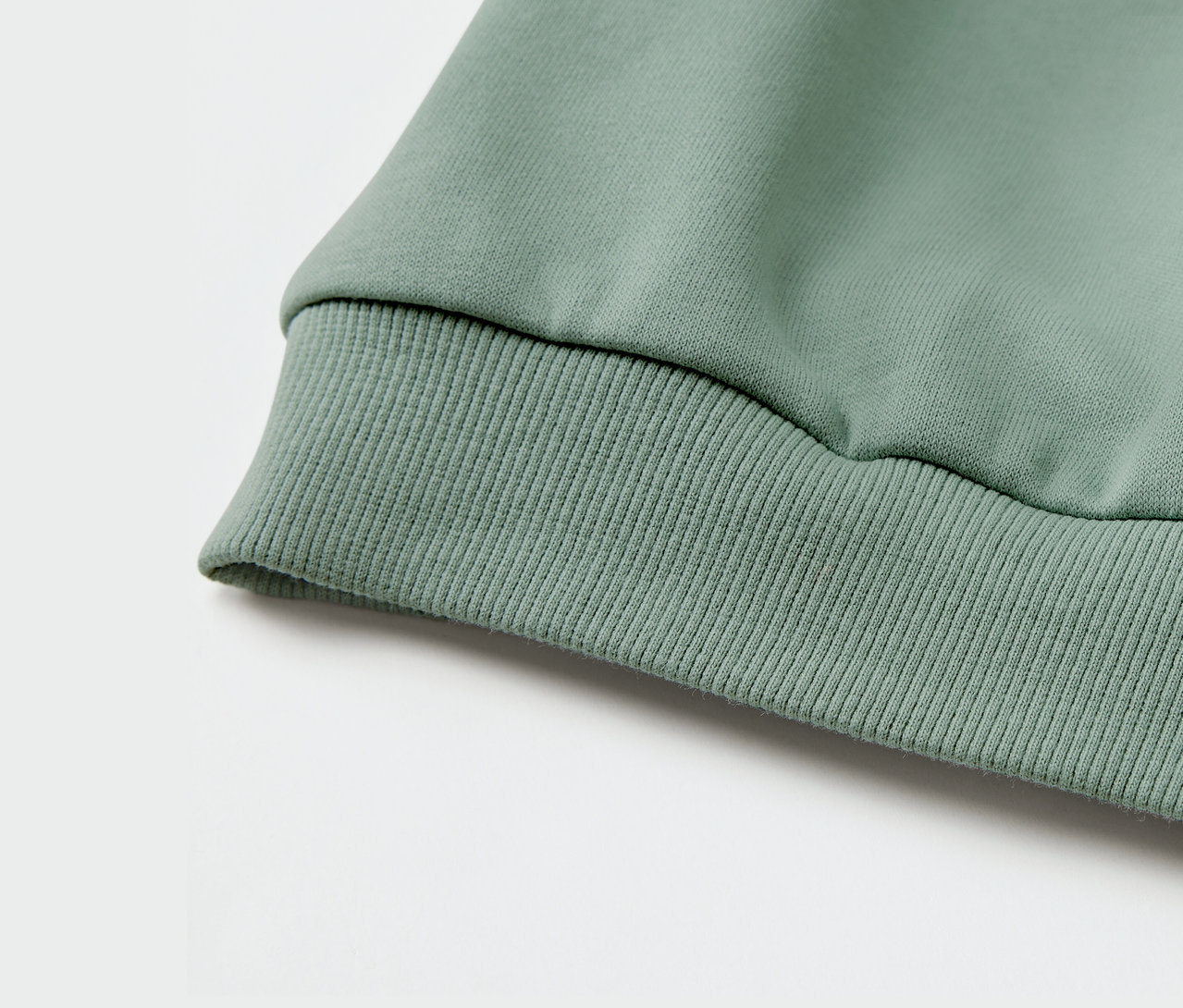 Detail zelené dětské mikiny s nápletem.