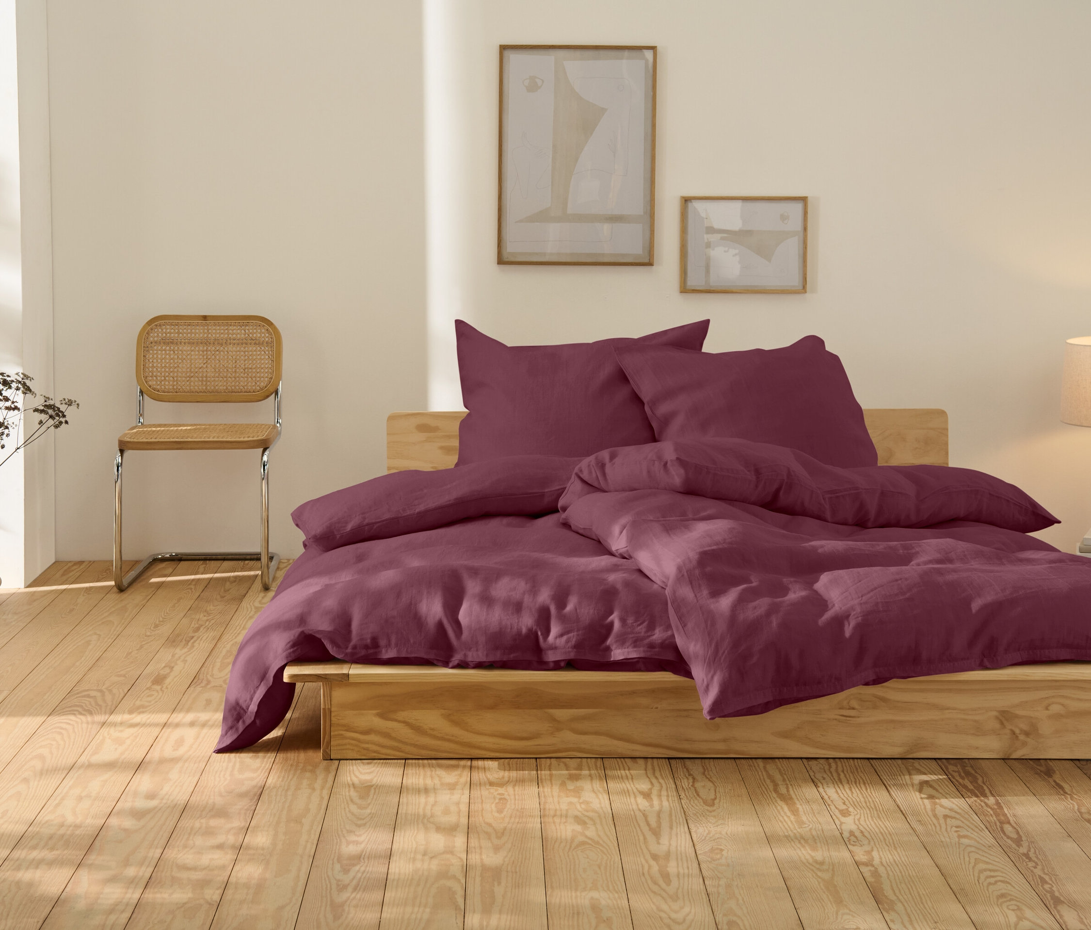 Postel s lněným povlečením bobulové barvy, standardní velikosti.