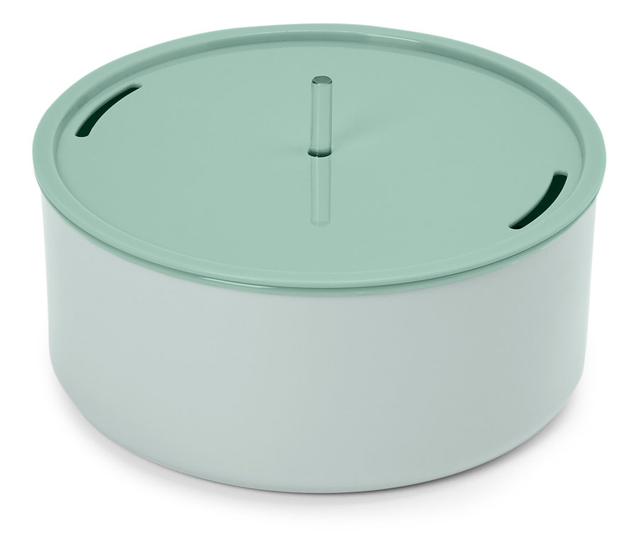 Kulatá, bílo-světle zelená fontána pro kočky stojí na bílém povrchu.