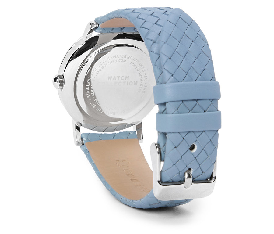 Detail stříbrných náramkových hodinek se světle modrým pleteným páskem.