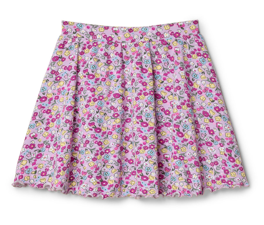Růžová sukně s květinovým vzorem leží na bílém pozadí.