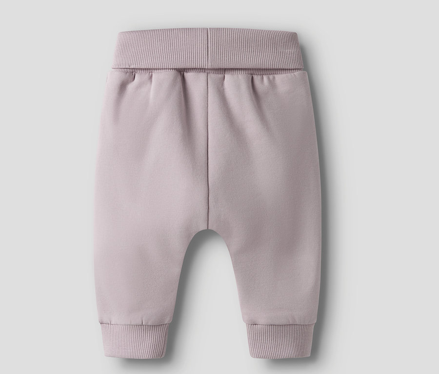 Detailní záběr na šeříkové dětské kalhoty s žebrovanými manžetami v pase a na kotnících.