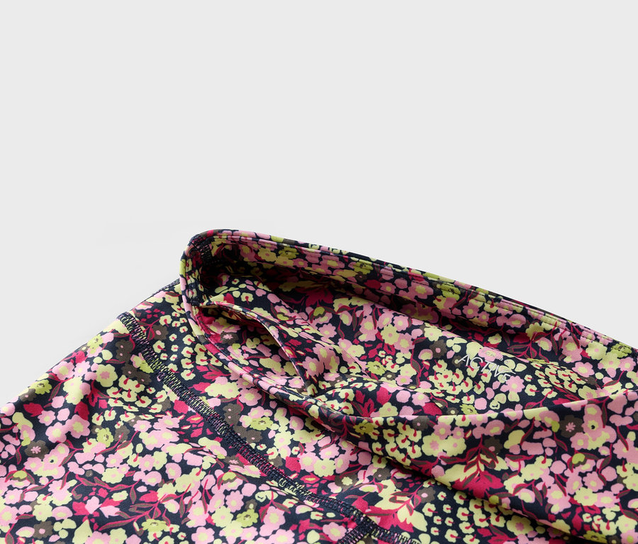 Detail květinových legín s tmavě modrým pasem a boční kapsou.