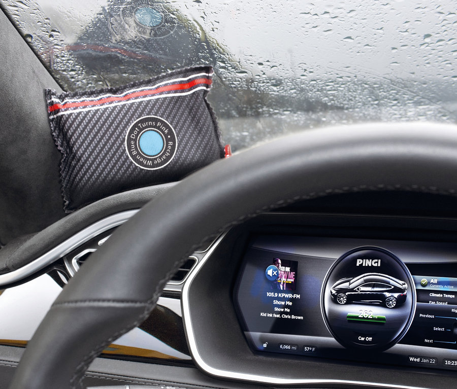 V interiéru auta leží na palubní desce odvlhčovač vzduchu do auta Pingi.