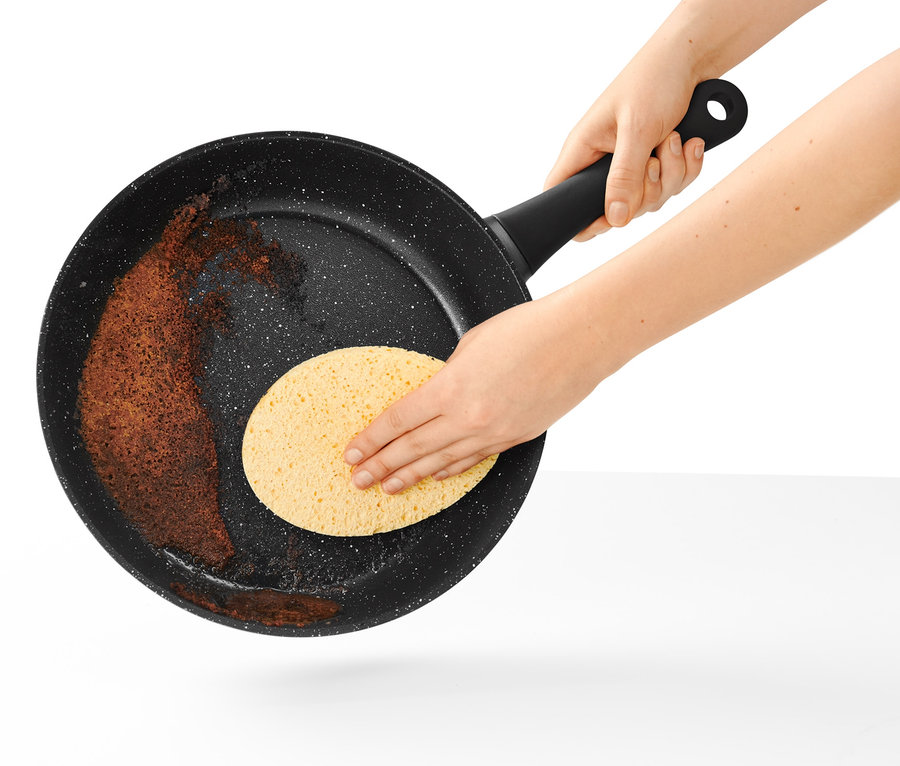 Čištění pánve o průměru 28 cm v kamenném designu houbičkou.