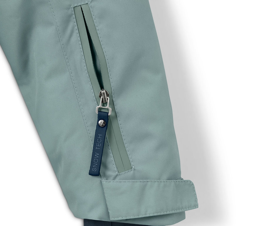 Detail dětské outdoorové a snowboardové bundy se zipem.