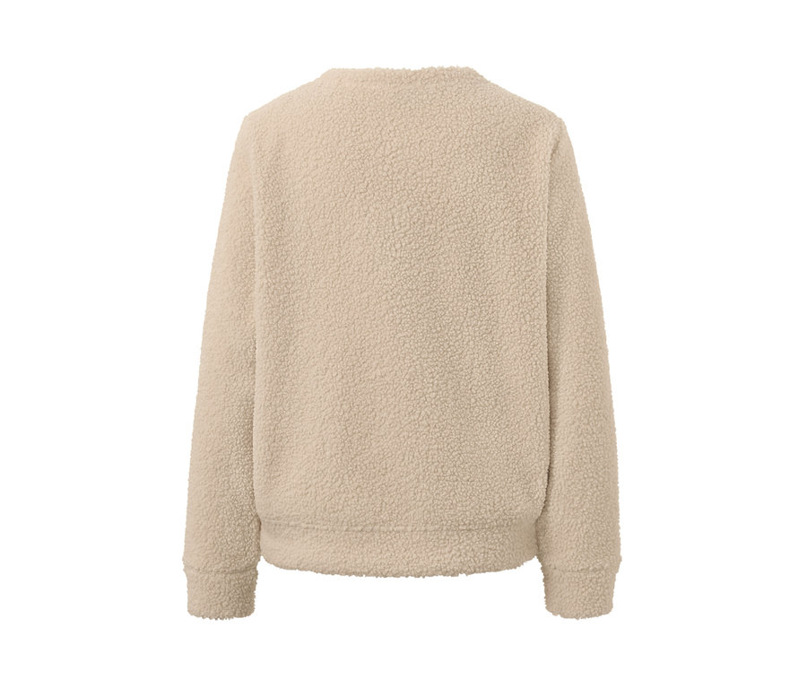 Detail měkoučkého svetru krémové barvy.