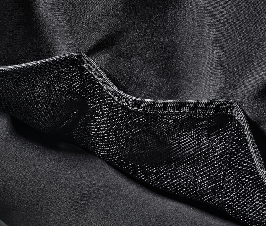 Detail černé sportovní tašky s vnější síťovanou kapsou.