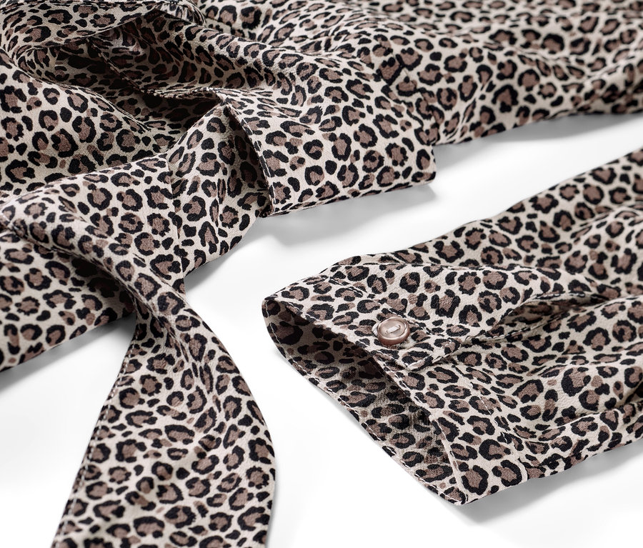 Detail tkaných šatů s leopardím potiskem.