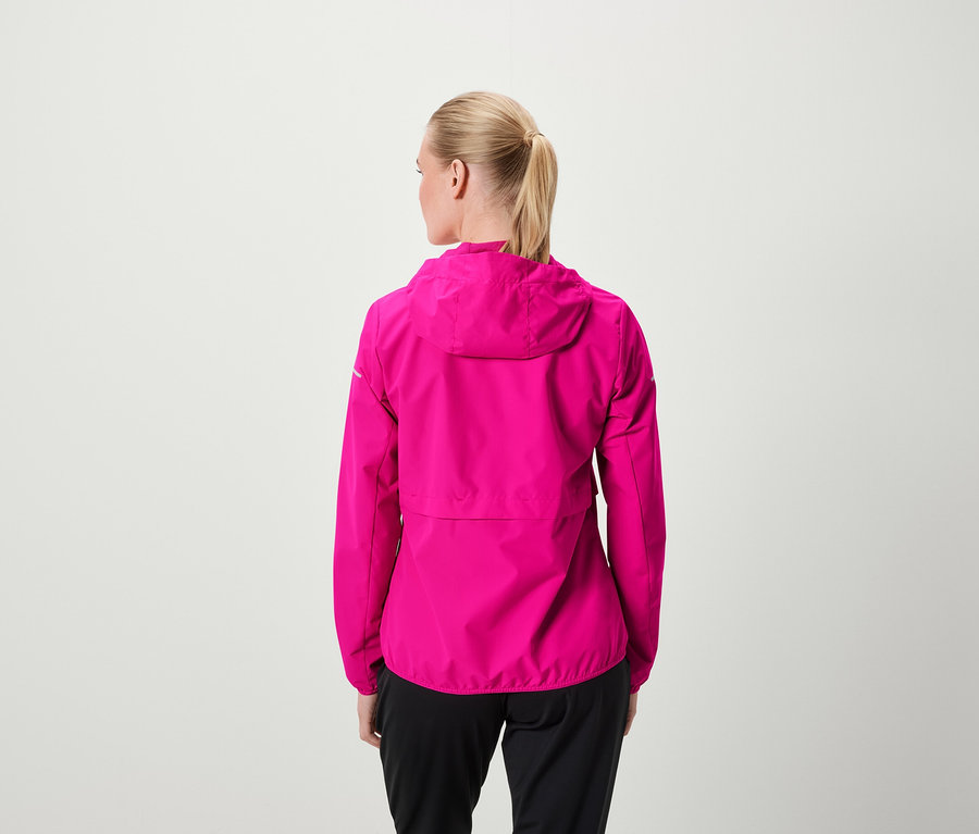 Zezadu je vidět žena s blond vlasy staženými do culíku, má na sobě růžovou bundu s kapucí a černé kalhoty.