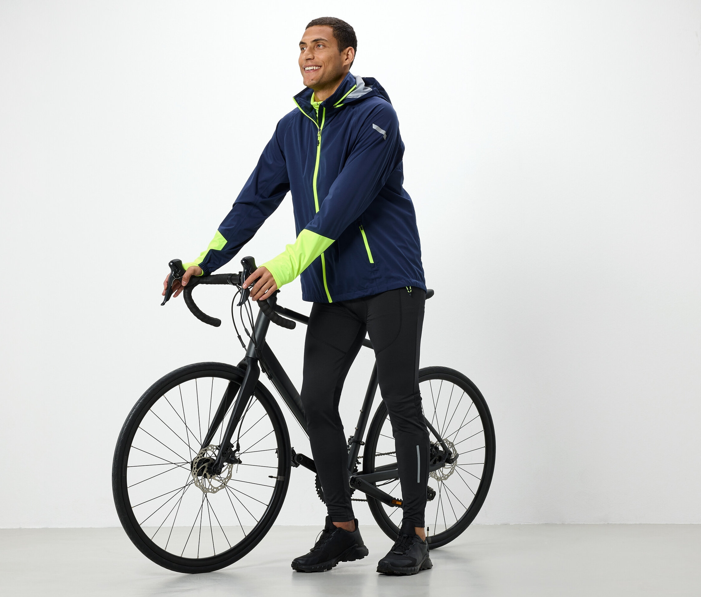 Muž v bundě drží černé kolo.