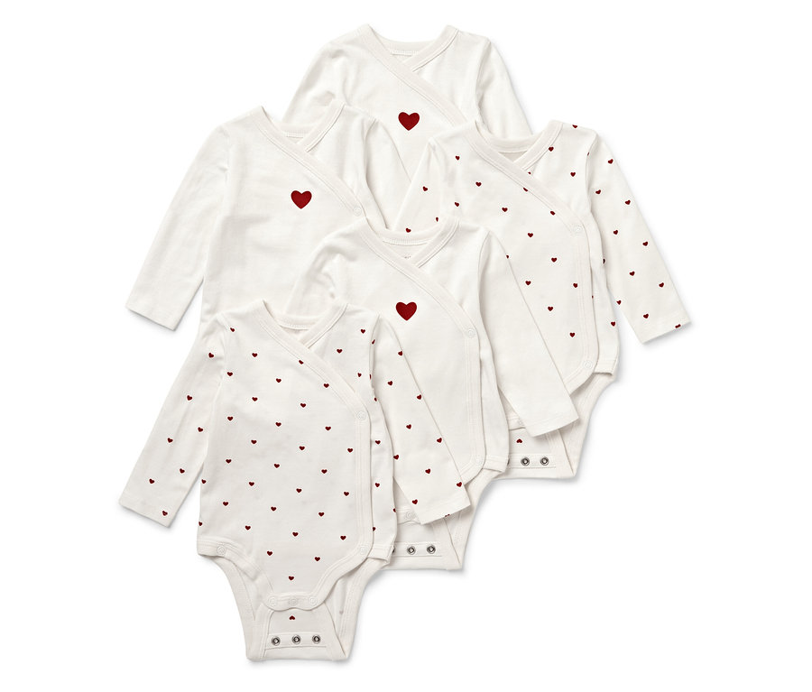 Pět bílých dětských body s dlouhým rukávem a červenými srdíčky.