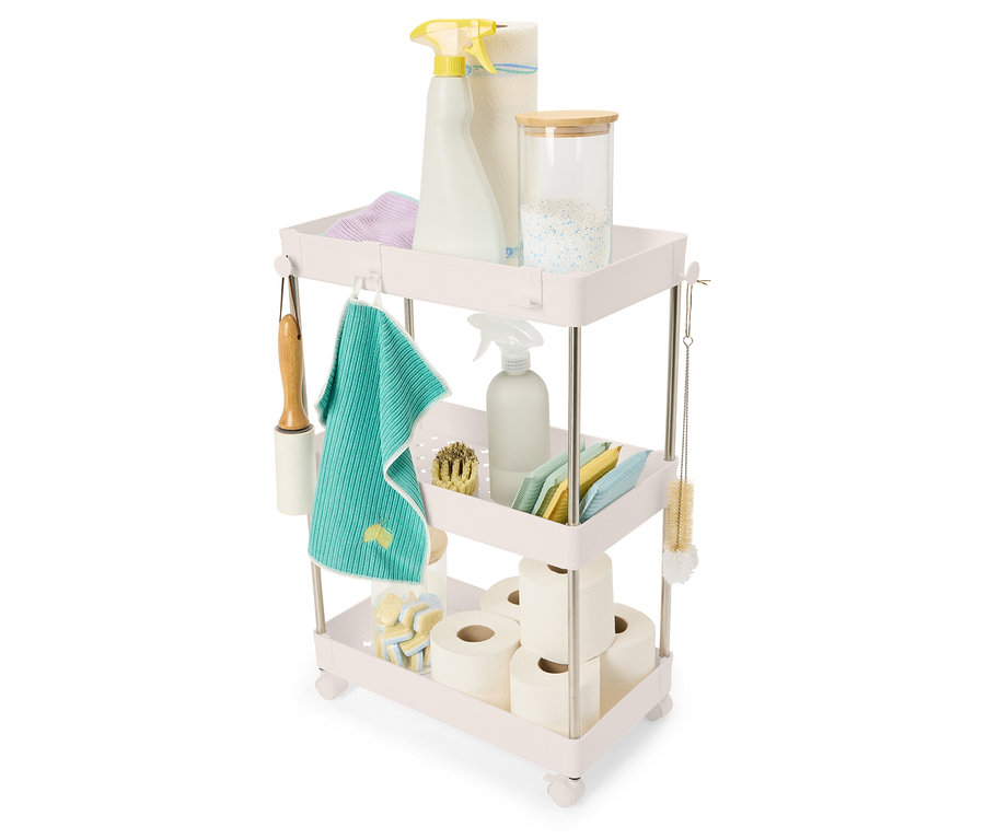 Čisticí prostředky a potřeby uspořádané na třípatrovém vozíku.