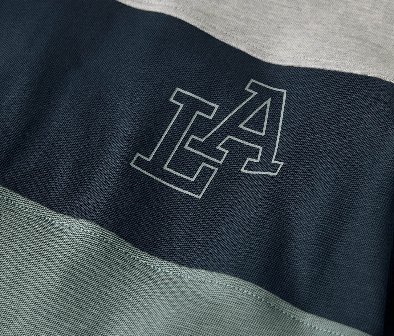 Detail dětského trika s dlouhým rukávem s nápisem LA.