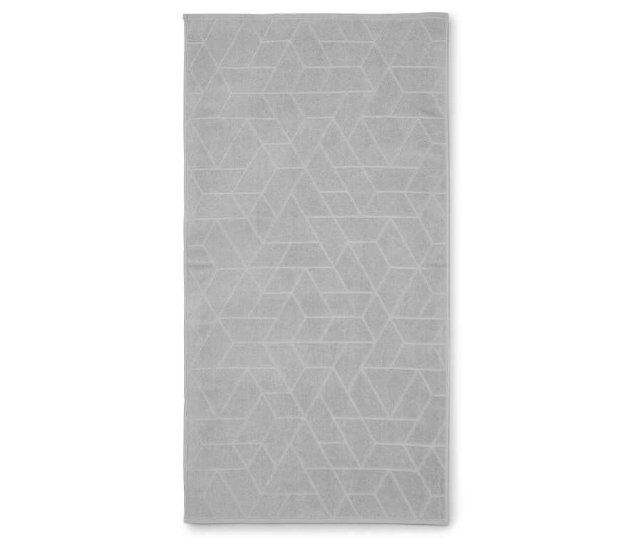 Šedý ručník s geometrickým vzorem leží naplocho.