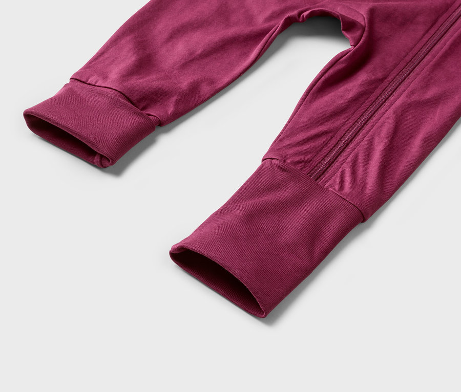 Detail rukávů a nohavic bordó kombinézy na zip.
