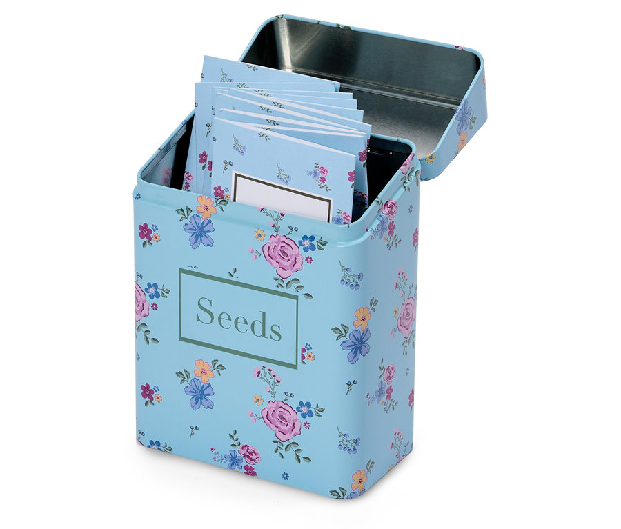 Otevřená světle modrá květinová krabička na semena s nápisem "Seeds" a několika malými poznámkovými bloky uvnitř.