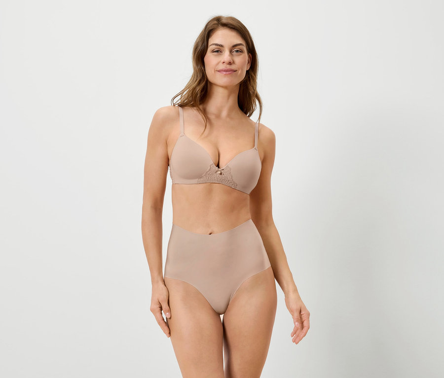 Žena má na sobě tělovou podprsenku a kalhotky na bílém pozadí.