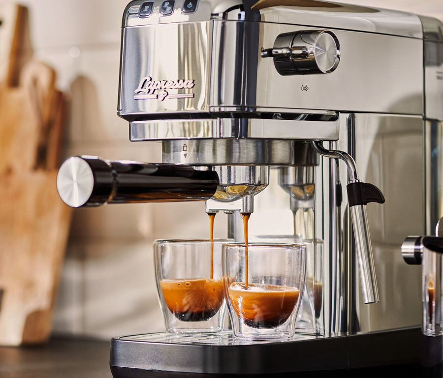 Stříbrný pákový kávovar »Lapressa« připravuje espresso do dvou skleněných šálků.