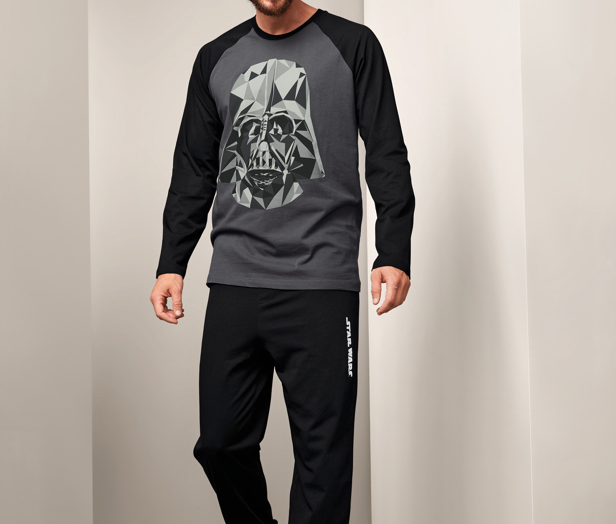 Muž má na sobě pyžamo Star Wars s grafickým potiskem Darth Vadera.