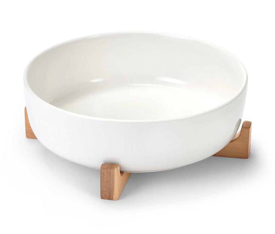 Bílá porcelánová zapékací forma na dřevěném podstavci.