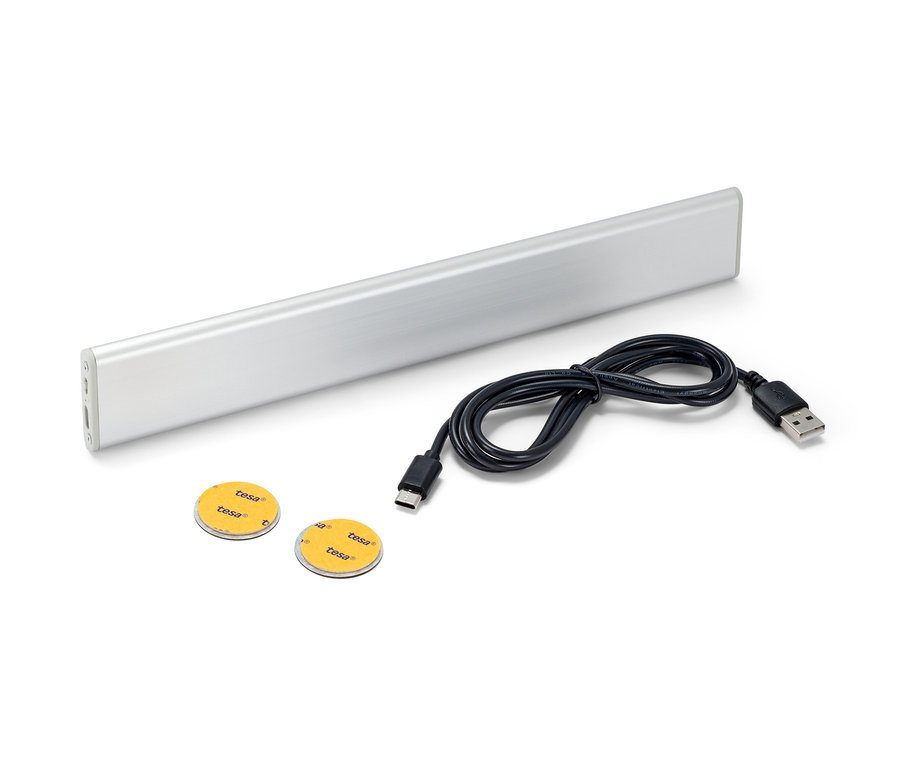 LED dobíjecí multifunkční svítidlo, černý kabel a dvě lepicí kolečka na bílém pozadí.