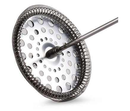 Detailní záběr na sítko french pressu s kovovým rámem a držadlem.