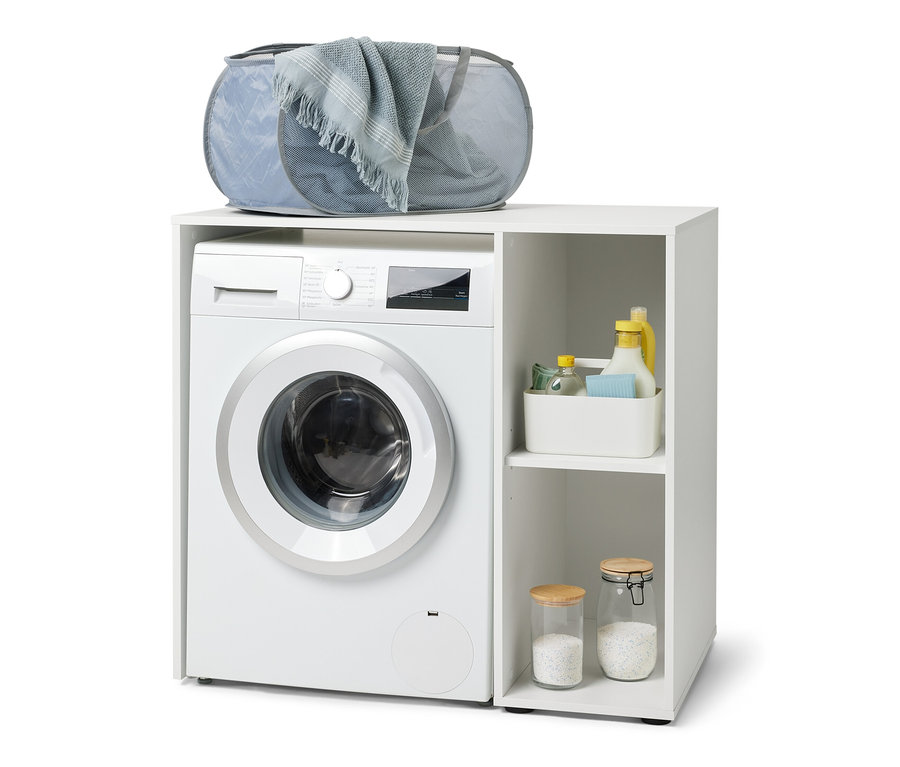 Na bílé pračce stojí bílý regál na pračku s bočním úložným prostorem. Na regálu je položen šedý koš na prádlo.