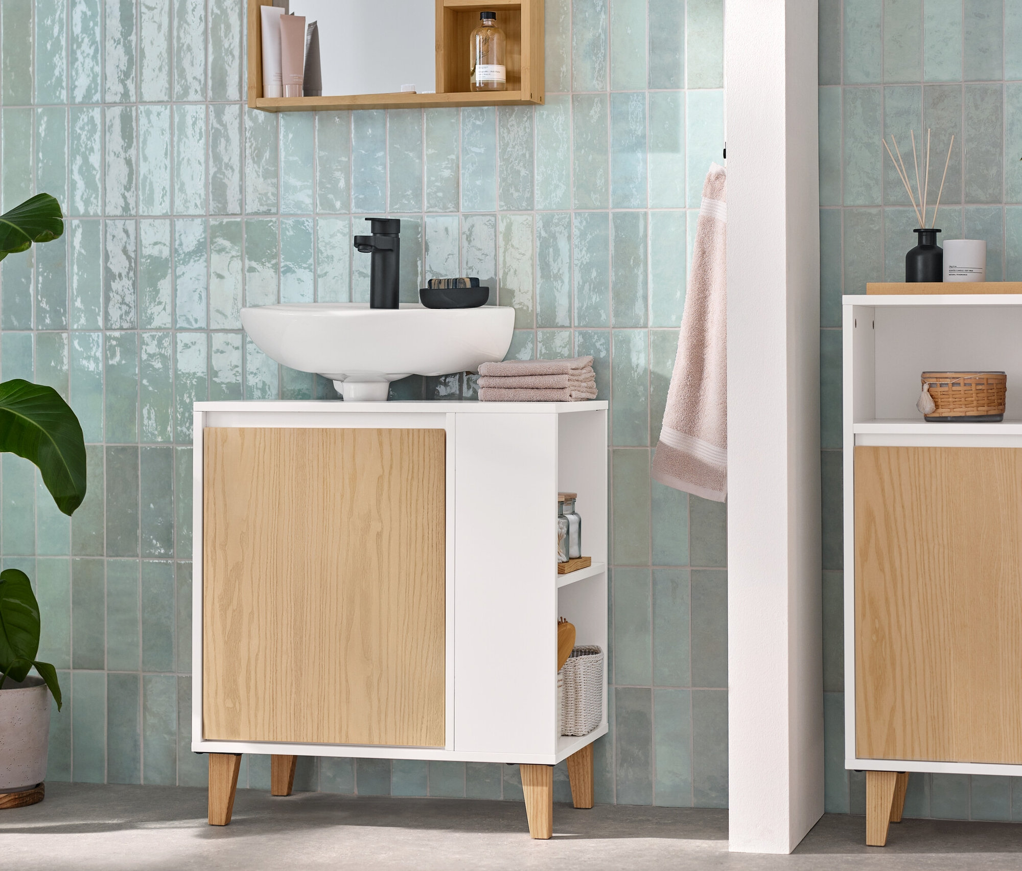 Koupelna s umyvadlovou skříňkou s dvířky a bočním prostorem, odkládací skříňkou se 2 dvířky a otevřeným prostorem a zrcadlem s poličkami.