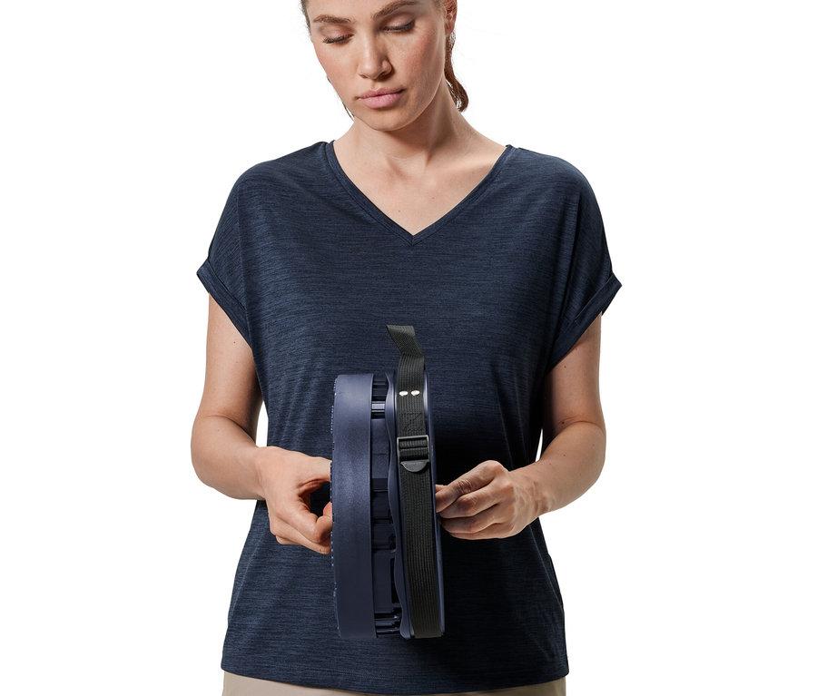 Žena drží teleskopickou kempingovou stoličku.