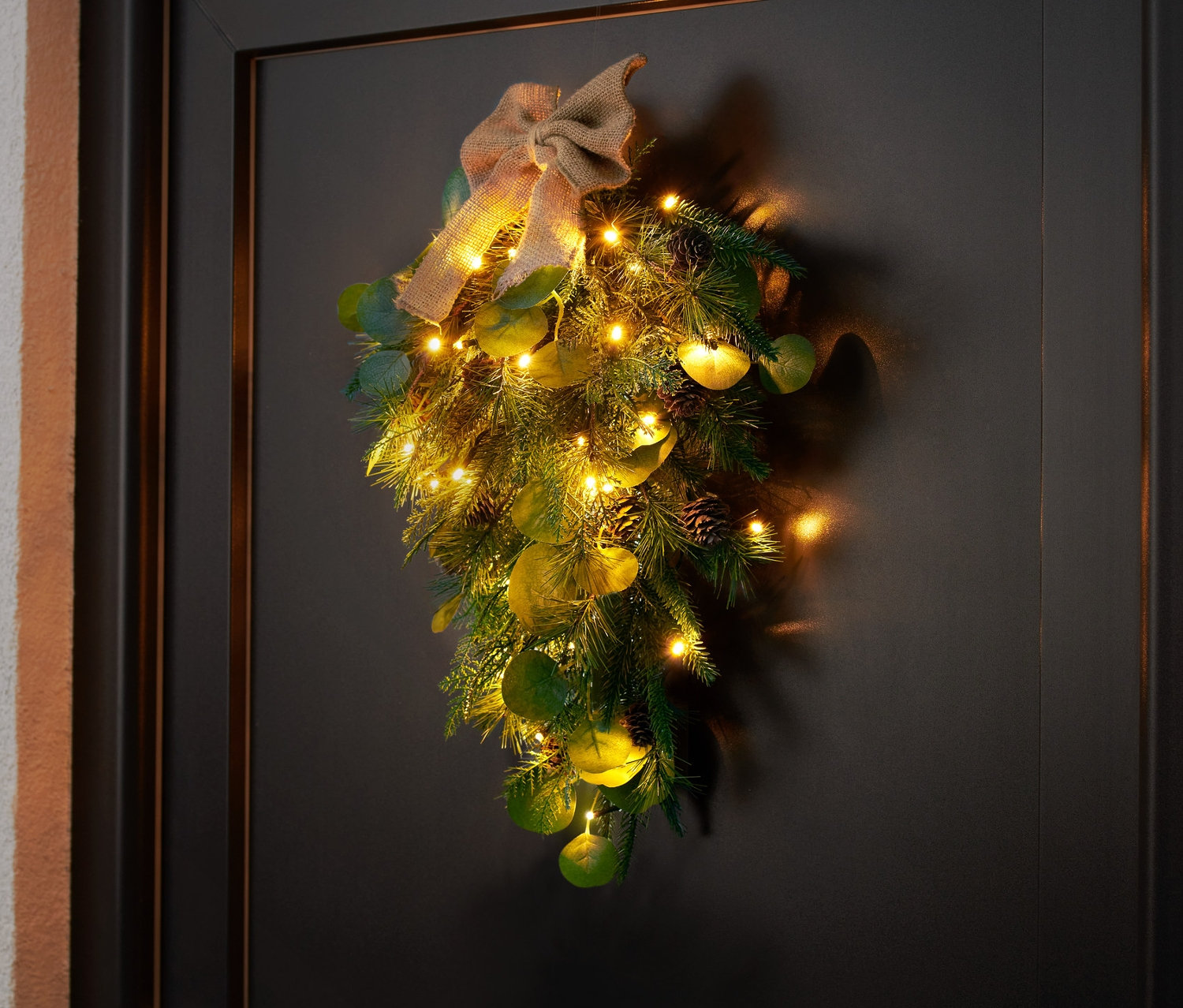 LED dekorace na dveře visí na černých dveřích.