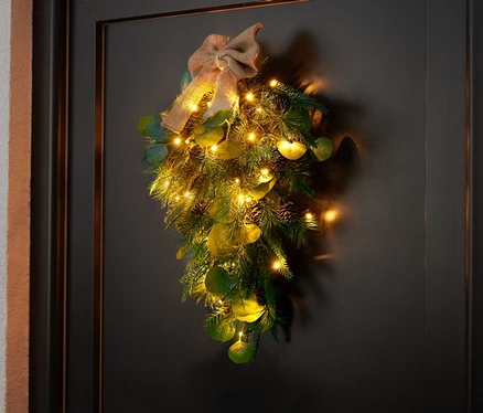 LED dekorace na dveře visí na černých dveřích.