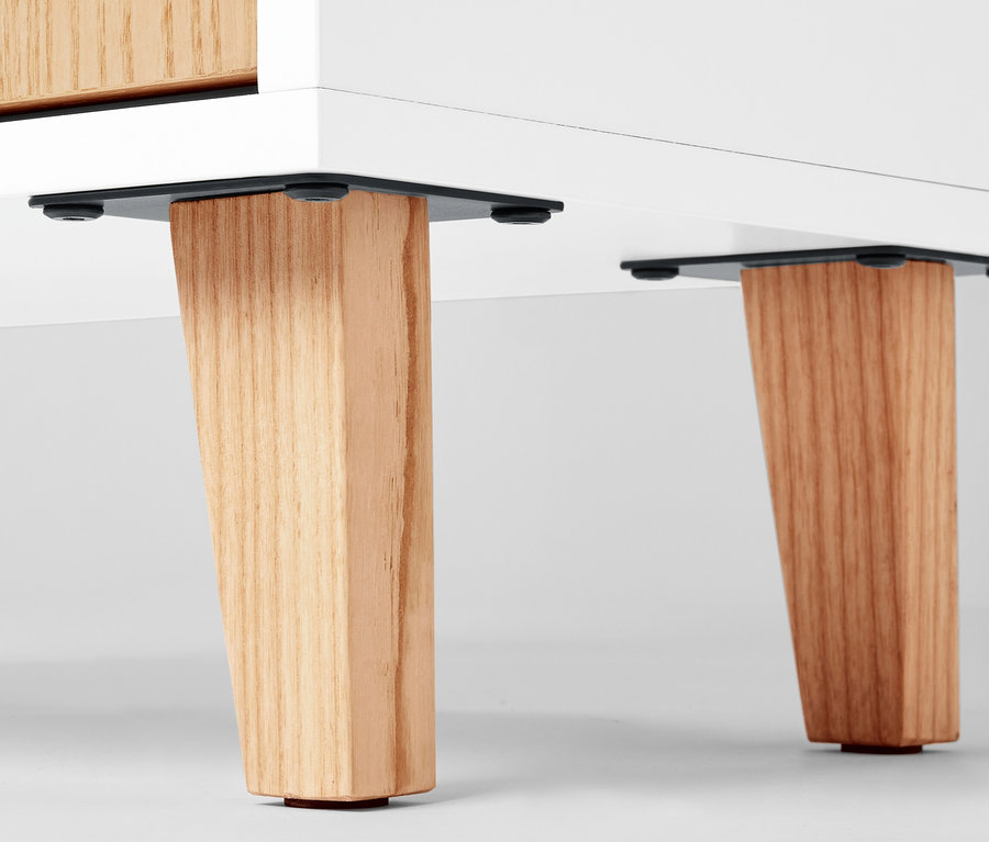 Detail odkladaci skrinky se dvema dvirky a otevrenym prostorem, ukazujici drevene nohy