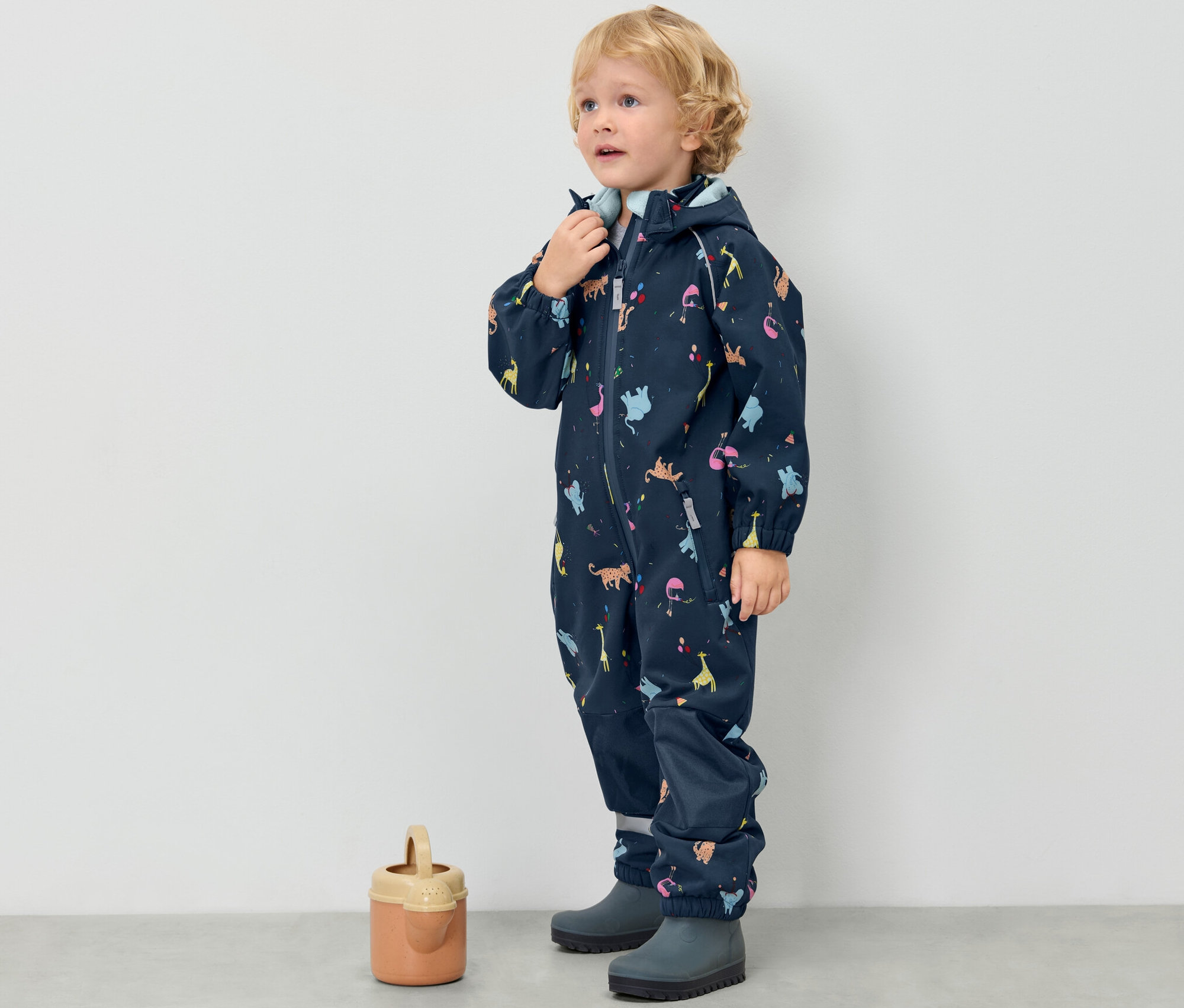 Chlapec v dětské softshellové kombinéze se zvířátky.