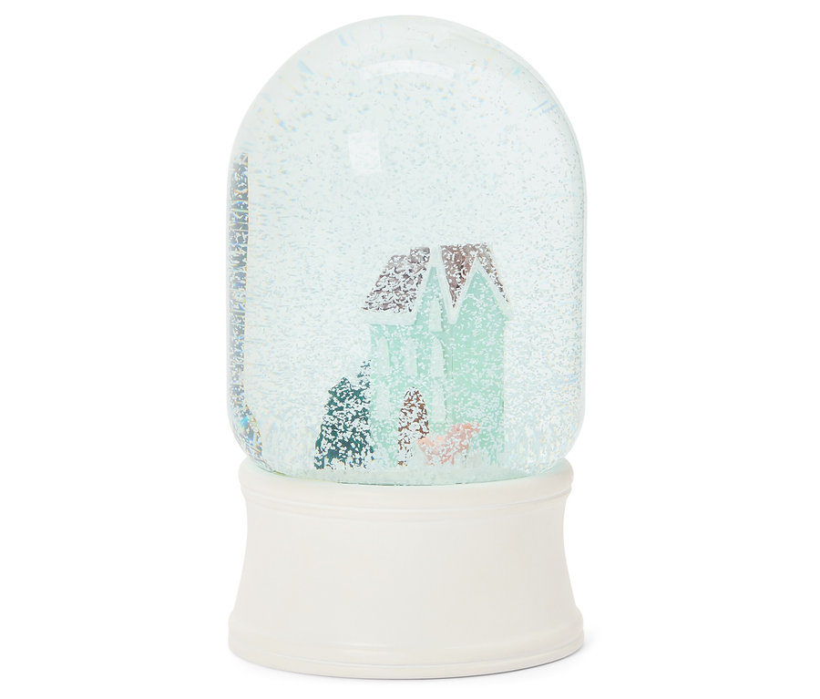 Sněhová koule s domem uvnitř na bílém podstavci.