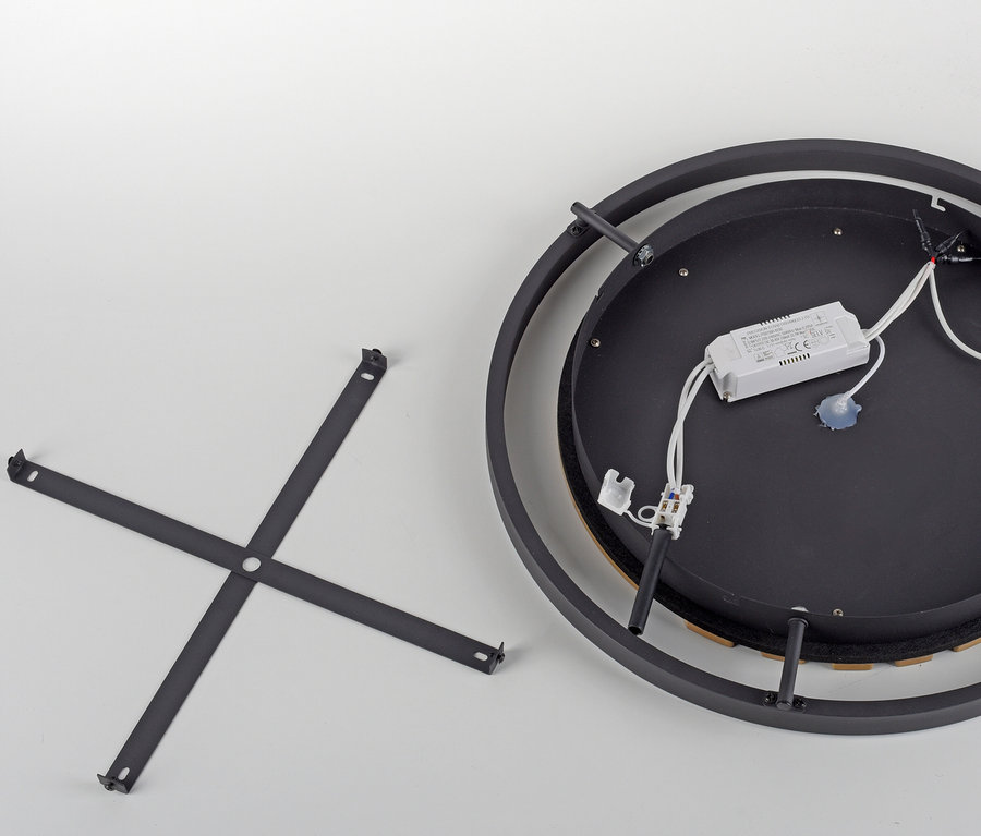 Detail černého stropního svítidla s montážním rámem a elektronikou.