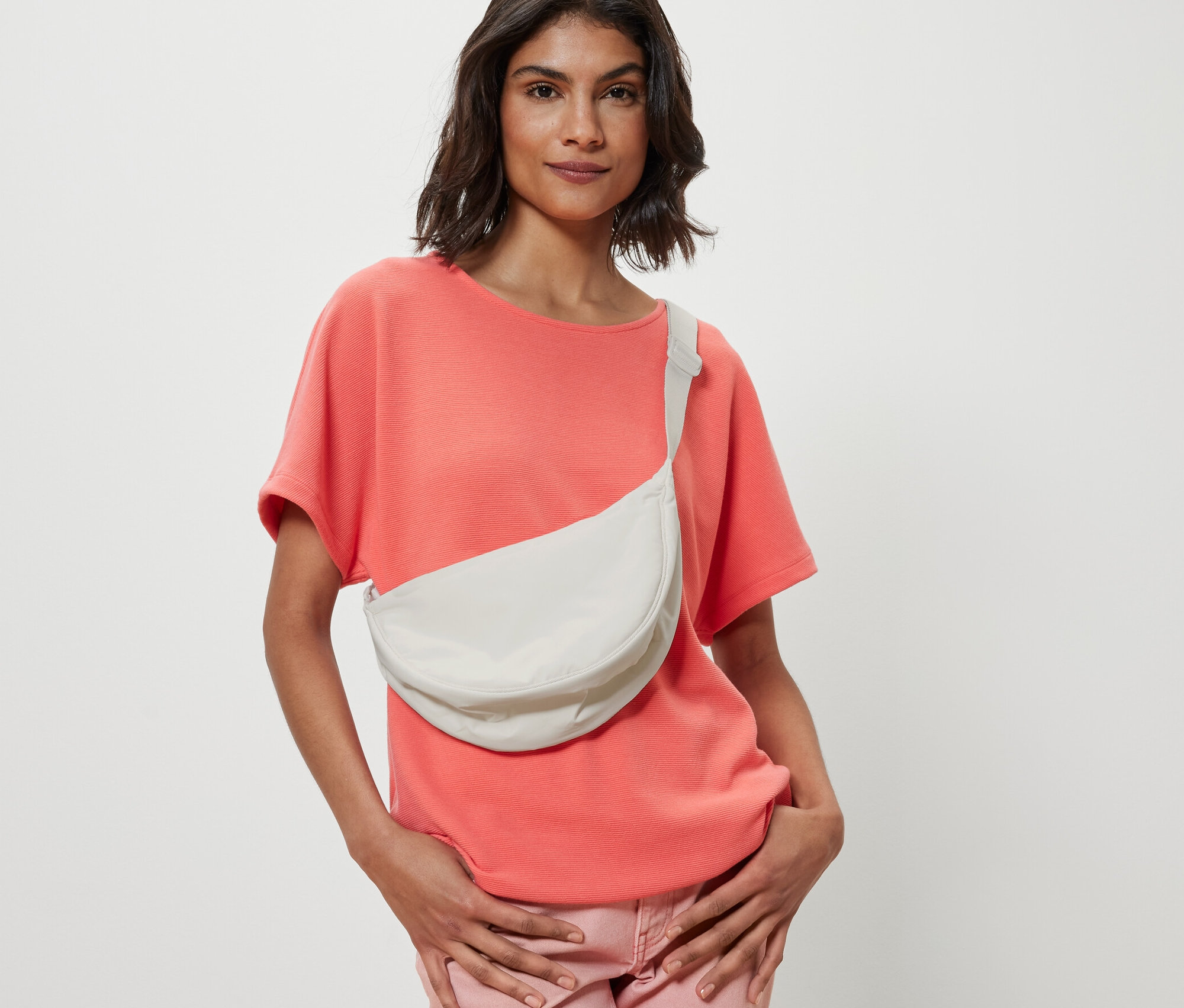 Žena s hnědými vlasy pózuje s ledvinkou.