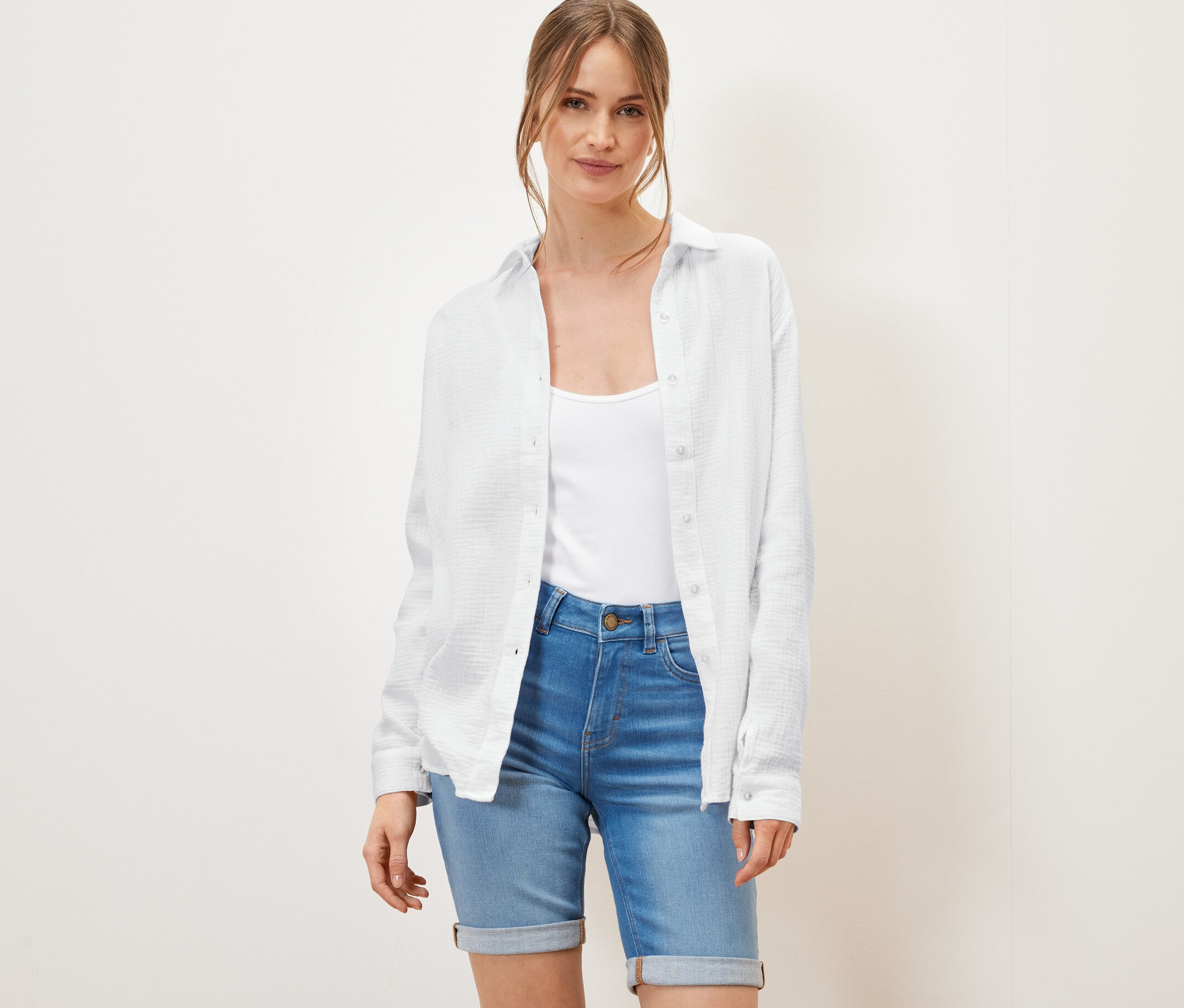 Žena má na sobě bílou mušelínovou halenku.