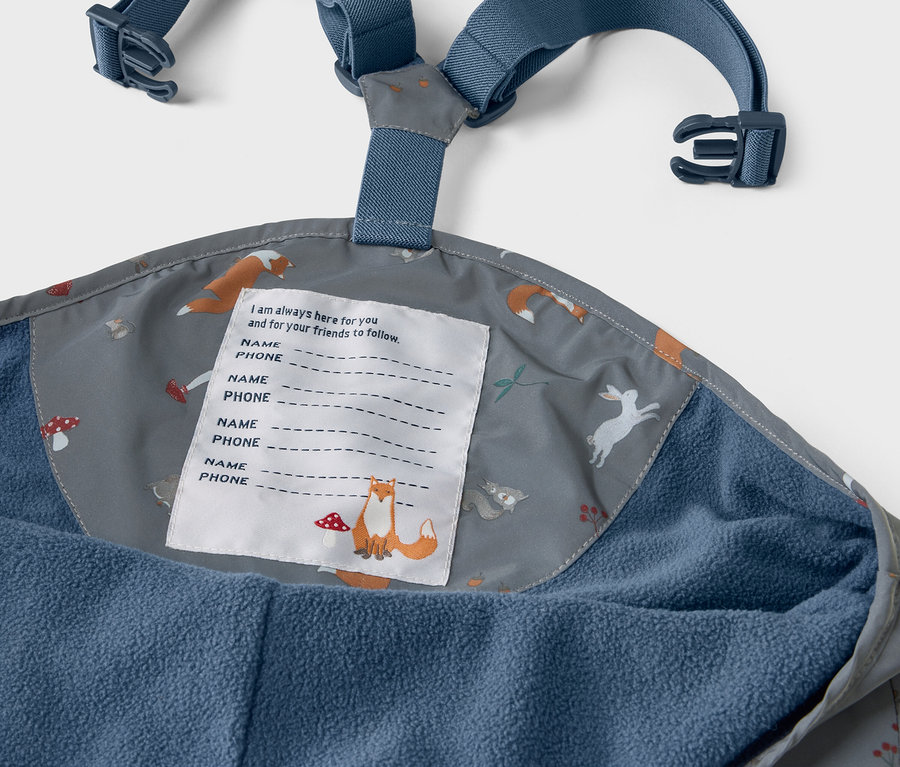 Detail dětských termo kalhot do deště s reflexními prvky, vnitřní strana kalhot s potiskem lišek, zajíců a hub.