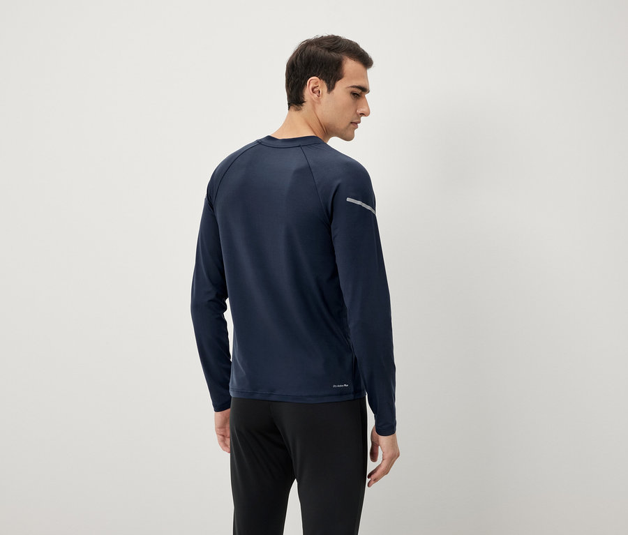 Muž zezadu v tmavě modrém tričku s dlouhým rukávem a černých kalhotách.